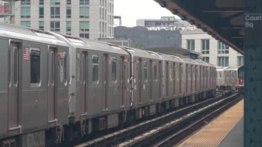 New York metro istasyonu. Metropolitan platformunda metro treni, Birleşik Devletler toplu taşımacılığı. Queens 'teki Court Square demiryolu hattında yükseltilmiş. New York yolcusu tren yolu trafiği, Long Island City