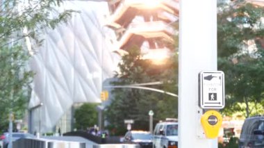New York City Hudson Yards mimarisi Chelsea, Manhattan Midtown binası, NYC, ABD. Odaklanamayan insanlar, şehir trafiği, 34. Cadde. Gün batımı ışınları yansıması. Kesişen yol trafik ışığı düğmesi.
