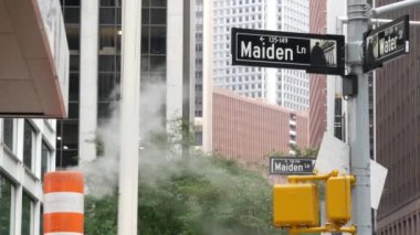 New York Su Sokağı 'nda buhar sızıntısı, turuncu buhar borusu yığını. Pipo dumanı. Con Edisons Buhar Operasyonları Sistemi, Manhattan şehir merkezi finans bölgesi mimarisi. Trafik ışığı