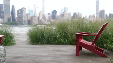 New York şehri kıyısı silueti, Manhattan şehir merkezi binaları, nehir kıyısındaki gökdelenler, doğu nehri suyu. Liman kenti manzarası, Gantry Plaza Park, Long Island, Queens. Birleşik Devletler. Koltuk sırası..