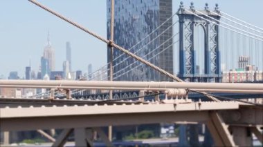 Brooklyn Köprüsü manzaralı New York City Manhattan Köprüsü. Şehir merkezindeki Empire State binası. ABD seyahat simgesi, New York silueti şehir manzarası. İkonik mimari kablolardan. Amerika Birleşik Devletleri 'ni Ziyaret Et.