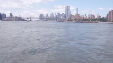 Feribot ile New York City şehir merkezinin silueti. Manhattan ve Brooklyn köprüsü. Feribottan Dünya Ticaret Merkezi gökdelenine. Doğu nehri kıyısı manzarası, nehir kenarındaki binalar, ABD.