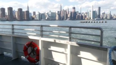 Feribottan New York City silueti. Manhattan şehir merkezinde, feribottan yükselen gökdelenler. Doğu nehri kıyısı manzarası, ABD mimarisi. Empire State, Chrysler Binası. Kamu güvenliği can simidi.