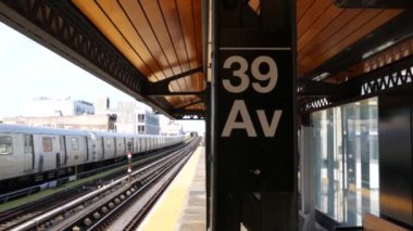 New York metro istasyonu. Metropolitan platformunda metro treni, Birleşik Devletler toplu taşımacılığı. Queens 'teki N demiryolu hattında yükseltilmiş. New York yolcusu tren yolu trafiği, Long Island Caddesi 39 numara.