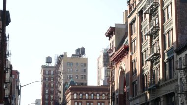 New York City Manhattan mimarisi. Şehir dışındaki konutlar. ABD 'de gayrimenkul. Kırmızı tuğla cephe. Yangın çıkışı, acil merdiven çıkışı. Çatıdaki su kulesi, çatıdaki tank..