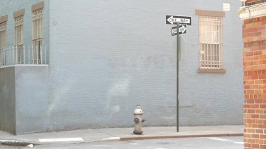 New York tek yönlü kavşak, Minetta caddesi kavşağı tek yönlü ok işareti. Manhattan Greenwich Village konut mimarisi, NYC, ABD. Mavi tuğla duvar, yangın musluğu.