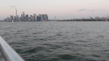 New York City feribottan Staten Island 'a ufuk çizgisi. Manhattan şehir merkezinde. Feribottan Dünya Ticaret Merkezi gökdelenine. Nehir kıyısı günbatımı manzarası, nehir kenarındaki binalar, Fidi, ABD