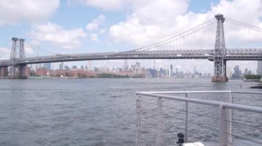 Feribottan New York City silueti. Manhattan şehir merkezindeki gökdelenler feribottan görünüyor. Doğu nehri kıyısı manzarası, nehir kıyısındaki binalar ABD suları yakınında. Williamsburg Köprüsü