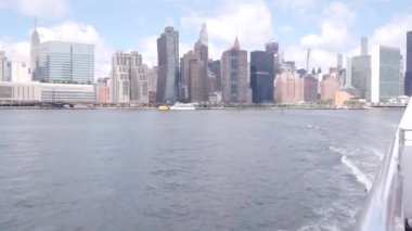 Feribottan New York City silueti. Manhattan şehir merkezinde, feribottan yükselen gökdelenler. Doğu nehri kıyısı manzarası, nehir kenarı mimarisi, ABD. Empire State, Chrysler Binası.
