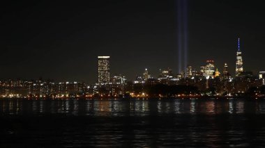 Tribute in Light, Manhattan from East river on September 11 Memorial Day. New York City downtown from ferry boat. World Trade Center. 9-11 Remembrance. Two beams in sky of United States of America USA clipart