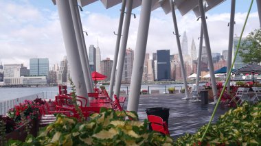 New York şehri kıyısı silueti, Manhattan şehir merkezi binaları, nehir kıyısındaki gökdelenler, doğu nehri suyu. Waterside şehir manzarası, Hunters Point rıhtım kolonları, Long Island, Queens. Birleşik Devletler.