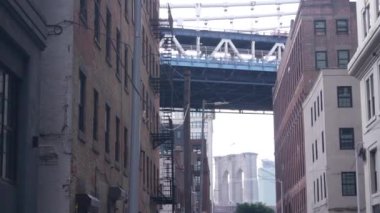 New York City Manhattan Köprüsü, Dumbo, Brooklyn Köprüsü. Brooklyn 'deki Plymouth caddesinde endüstriyel kırmızı tuğla binalar. Yangın merdivenli klasik NYC mimarisi. İki köprü turist manzaralı.