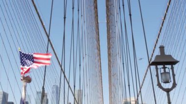 Brooklyn Köprüsü 'nden New York' a Amerikan bayrağı. Özgürlük, özgürlük, demokrasi ve bağımsızlığın vatansever sembolü, köprü kabloları. Amerika Birleşik Devletleri 'nin yıldızlı bayrağı rüzgarda savruluyor. ABD 'ye Seyahat.