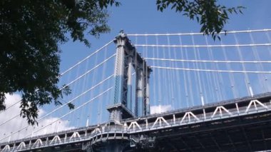 Manhattan Köprüsü 'nden Brooklyn Dumbo' ya. New York 'un sembolü, Amerika' nın seyahat yeri. Amerika Birleşik Devletleri 'nin mimarisi, turist simgesi. Kablolu yayın köprüsü. Kablolar, mavi gökyüzü, park ağacı yaprakları..