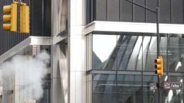 Buhar sızıntısı, New York Şehri Kilisesi, Fulton Caddesi, turuncu buhar boruları. Sıcak duman piposu. Con Edison Buhar Operasyonları Sistemi, Manhattan şehir merkezi finans bölgesi mimarisi. Trafik ışığı