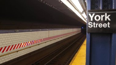 New York şehri içi boş metro istasyonu, yeraltı metro platformu tabelası. Metro demiryolu yolcusu toplu taşıma, Birleşik Devletler. Bakış açısı. York Caddesi 'ndeki yazı tahtası. Brooklyn Şehir Merkezi