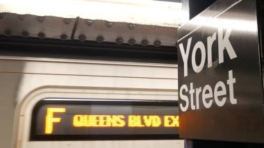 New York metro istasyonu içi, yeraltı metro platformu tabelası. Metro treni, demiryolu yolcusu toplu taşıma, Birleşik Devletler. York Caddesi 'ndeki yazı tahtası. Brooklyn Şehir Merkezi, New York.