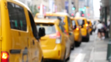 New York 'ta. Manhattan caddesinde sarı taksi durakları. Midtown 8. Cadde 'de bir sürü taksi var. Penn İstasyonu yakınında yolcu bekleyen bir taksi var. Dağınık şehir manzarası, yayalar