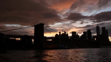 Brooklyn Köprüsü, New York City Manhattan şehir merkezi silueti, finans bölgesi şehir manzarası. Birleşik Devletler Dünya Ticaret Merkezi gökdeleni. Waterfront Pebble Sahili, Dumbo, ABD. Dramatik alacakaranlık bulutlu gökyüzü.