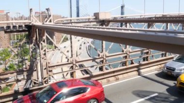 Brooklyn Köprüsü 'nde arabalar, New York City Manhattan Köprüsü manzaralı. Sarı taksi, trafik ve mimari. East River 'ın ikonik simgesi. ABD 'ye Seyahat.