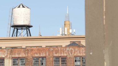 New York City klasik endüstriyel bina dış mimarisi, ABD. Tipik kırmızı tuğla, ön cephedeki pencereler. Çatıdaki su kulesi, Queens, ABD 'de bir depo. Chrysler binasının tepesi..