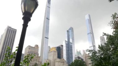 New York Şehri Manhattan Midtown. 5. Cadde 'deki Central Park, ABD. Amerika 'nın simgesi, NYC, ABD' deki şehir parkı. Gökdelen binaları mimarisi, 59 sokak silueti. Yeşil ağaçlar.