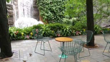 New York şehri hayatı, şehir parkı, Greenacre Park şelalesi. Amerikan Manhattan Midtown, ABD. Eğlence bölgesi yaz çiçekleri, ağaçlar yeşillik. Boş sandalyeler ve masalar. New York 'ta yeşil vaha.