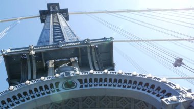 Manhattan Köprüsü 'nden Brooklyn Dumbo' ya. New York 'un sembolü, Amerika' nın seyahat yeri. Birleşik Devletler 'in mimarisi, turizm simgesi. Kablolu yayın köprüsü. Yaya yolundan kablolar ve gökyüzü. Güneş ışınları.