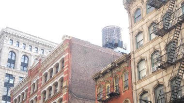 Broadway caddesi yakınlarındaki New York City Manhattan Soho moda bölgesi. Amerikan şehir binası cephesi, eski klasik Amerikan mimarisi. NYC 'de ikamet eden gayrimenkul. Çatıda su deposu var.