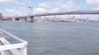 Feribottan New York City silueti. Manhattan şehir merkezindeki gökdelenler feribottan görünüyor. Doğu nehri kıyısı manzarası, nehir kıyısındaki binalar ABD suları yakınında. Williamsburg Köprüsü