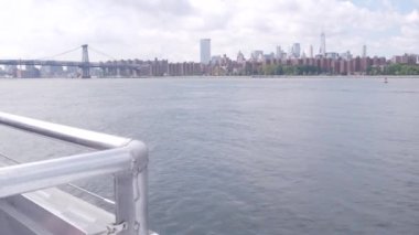Feribottan New York City silueti. Manhattan şehir merkezindeki gökdelenler feribottan görünüyor. Doğu nehri kıyısı manzarası, nehir kıyısındaki binalar ABD suları yakınında. Williamsburg Köprüsü