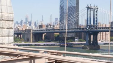 Brooklyn Köprüsü manzaralı New York City Manhattan Köprüsü. Şehir merkezindeki Empire State binası. ABD 'yi gezmek, turistik yerleri gezmek. New York Skyline şehir manzarası. Doğu Nehri suyunun üzerindeki ikonik mimari kablolardan..