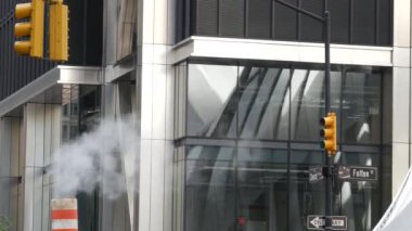 Buhar sızıntısı, New York Şehri Kilisesi, Fulton Caddesi, turuncu buhar boruları. Sıcak duman piposu. Con Edison Buhar Operasyonları Sistemi, Manhattan şehir merkezi finans bölgesi mimarisi. Trafik ışığı