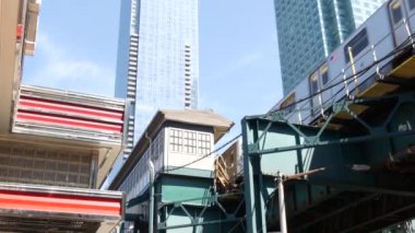 New York metrosu, metro köprüsü, caddenin üstündeki metro yolu. Demiryolu taşımacılığı. Demiryolu hattı. Kafe lokantası. Court Square, Long Island City, Queens, ABD.