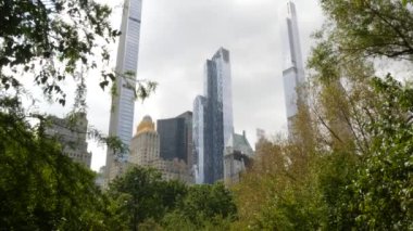 New York Şehri Manhattan Midtown. 5. Cadde 'deki Central Park, ABD. Amerika 'nın simgesi, NYC, ABD' deki şehir parkı. Gökdelen binaları mimarisi, 59 sokak silueti. Yeşil ağaçlar.