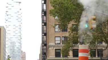 Buhar sızıntısı, New York Şehri Kilisesi, Fulton Caddesi, turuncu buhar boruları. Sıcak duman piposu. Con Edison Buhar Operasyonları Sistemi, Manhattan şehir merkezi finans bölgesi mimarisi. Trafik ışığı