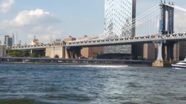 Feribot ile New York City şehir merkezinin silueti. Manhattan ve Brooklyn köprüsü. Feribottan gökdelen. Doğu nehri kıyısı manzarası, nehir kenarındaki binalar, ABD.