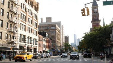 New York, ABD - 10 Eylül 2023 Manhattan Greenwich Village Caddesi, 6. Amerika Bulvarı kavşağı. Yol trafiği, sarı taksi. Amerikan Dünya Ticaret Merkezi. Jefferson Pazar Kütüphanesi.