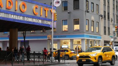 New York, United States - 10 Sept 2023: Manhattan Midtown street. Radio City Music Hall, Rockefeller Center, USA. People pedestrian, urban traffic, 6 Sixth Americas avenue crossroad, yellow taxi cab. clipart