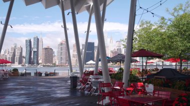 New York, Amerika Birleşik Devletleri - 30 Ağustos 2023 Waterfront Skyline, Manhattan Midtown binaları, East River 'daki nehir manzaralı gökdelenler. Liman kenti manzarası, Hunters Point rıhtım kolonları, Long Island, Queens.