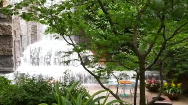 New York şehri hayatı, şehir parkı, Greenacre Park şelalesi. Amerikan Manhattan Midtown, ABD. Çiçek tarlasında tropikal çiçekler, ağaçlar yeşillik. NYC 51. Cadde 'deki yeşil vaha..