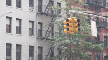 New York caddesi kavşağı, sarı trafik ışığı, ulaşım yolu kavşağı, Birleşik Devletler. Konut mimarisi. New York Emlak, yangın merdivenli kırmızı kahverengi tuğlalı ev. Manhattan.