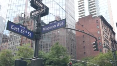 New York City kavşağı, Manhattan köşesi, Madison Bulvarı, sokak kavşağı tabelası. Midtown merkez bölgesi mimarisi, Birleşik Devletler. Tek yönlü ok işareti, gökdelenler. Düşük açı.