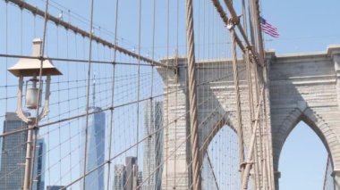 Brooklyn Köprüsü 'nden Manhattan' a, kablolar ve mavi gökyüzü. New York City silueti, finans bölgesi şehir manzarası. Dünya Ticaret Merkezi, ABD seyahat merkezi. Amerika Birleşik Devletleri Mimarisi.