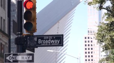 Broadway caddesi tabelası, Manhattan şehir merkezi finans bölgesi mimarisi. New York City, Fulton caddesi köşe tabelası. Dünya Ticaret Merkezi yakınlarında sarı trafik ışığı. Metro girişi. Tek yönlü ok
