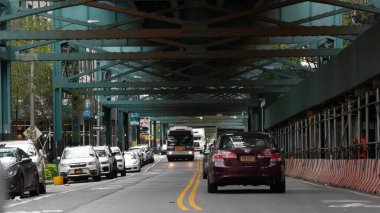 New York, Birleşik Devletler - 31 Ağustos 2023: sokağın üstündeki metro yükseltilmiş. Yolun üzerindeki Metropolitan Köprüsü, Queens. Long Island metro hattı, Court Meydanı. Tren yolu altında arabalar ve otobüsler. NYC şehir hayatı.