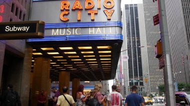 New York, ABD - 10 Eylül 2023 Manhattan Midtown Caddesi. Radio City Music Hall, Rockefeller Center, ABD dönüm noktası. 6. Amerika Bulvarı, NYC 'de yaya ve şehir trafiği