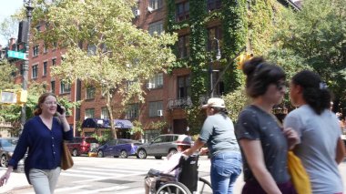 New York City, United States - 6 Sept 2023: Manhattan Midtown Irving street corner, crossroad intersection, Gramercy, USA. People, pedestrians crossing. Red brick house wall covered ivy plant leaves. clipart