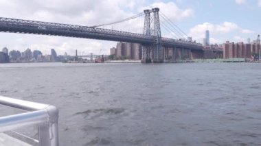 Feribottan New York City silueti. Manhattan şehir merkezindeki gökdelenler feribottan görünüyor. Doğu nehri kıyısı manzarası, nehir kıyısındaki binalar ABD suları yakınında. Williamsburg Köprüsü