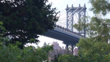 Manhattan Köprüsü 'nden Brooklyn Dumbo' ya. New York 'un sembolü, Amerika' nın seyahat yeri. Amerika Birleşik Devletleri 'nin mimarisi, turist simgesi. Kablolu yayın köprüsü. Kablolar, gökyüzü, park ağacı yaprakları..